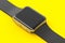 Stainless gold smart watch or fitness tracker isolated on yellow background.