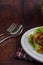 Stainless spoon and fork and spicy salad of sardine