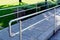 Stainless steel double rail along concrete tile paved handicapped ramp
