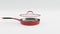 Stainless steel frying pan with glass lid and chrome cookware on white