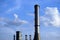 Stainless steel  industrial smoke stacks. blue sky and white clouds