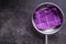 Stainless steel kitchen frying pan with purple towel on concrete board