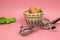 Stainless steel manual hand crank egg beaters, eggs, and measuring spoons on pink pastel background