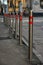 Stainless steel parking bollards with red stripes along roadway on street