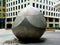 Stainless steel public sculpture with modern style white office building in the background