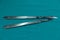 Stainless steel scalpel handle number 3 and 4 with blade on surgical green drape fabric