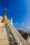 Stair way upward to the golden pagoda on the hill with blue sky background at Wat Khao Rup Chang or Temple of the Elephant Hill, o