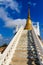 Stair way upward to the golden pagoda on the hill with blue sky background at Wat Khao Rup Chang or Temple of the Elephant Hill, o