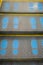 Staircase escalator in shopping mall moving up with blue footprint graphic symbol