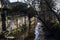 Staircase of a group of houses by the edge of a stream of water on a sunny day in the italian countryside