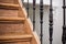 Staircase Handrailing in Old Historic Building. Interior Decor of Vintage Stairs with Metal Ornament and White Wall Background.