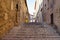 A staircase in an italian village with a yellow garbage can Corinaldo, Marche, Italy