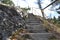 Stairs going up along rock with railing on the right
