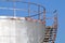 Stairway casts a heavy on an old silver storage tank. Stairs