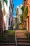 Stairway between multicolored buildings with colorful walls and green plants on narrow street in old quarter of historical centre