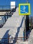 Stairway overhead pedestrian crossing covered with snow. Sign crosswalk. Repair work