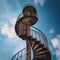 Stairway to Heaven. A spiral antique metal staircase goes high up into sky