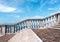 Stairway with white balustrade with seascape and blue sky with clouds