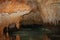 Stalactites and stalagmites hang over a clear pool in the Crystal Caves in Grand Cayman.