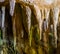 Stalagmite stones hanging on the ceiling of a drip cave, underground grotto background