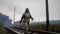 A stalker walks along railway tracks in a desolate, dreary post-apocalyptic world. A man surviving a nuclear apocalypse