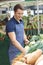 Stall Holder Arranging Display At Vegetable Market