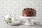 Stand with tasty homemade chocolate cake and tea set