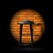 Stand up comedy show - microphone on stool in ray of spotlight and brick wall