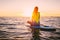 Stand up paddle boarding on a quiet sea with warm summer sunset colors. Relaxing on ocean