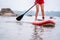 Stand up paddle boarding on the river, close-up of legs