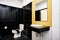 Standard facilities of generic toilet room of small hotel or apartment decoration with glossy ceramic in black and yellow wall wit