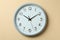 Standard gray home clock on beige background