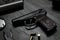 Standard handgun on dark table. Semi-automatic pistol
