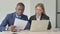 Standing African Businessman Helping Female Employee at Work, Guiding