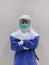 Standing Asian woman doctor wear full Personal Protective Equipment PPE and PAPR Powered Air Purifying respirator and surgical