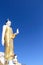 Standing Buddha image on bright blue sky background at  phra that doi khum  temple in Chiang Mai of Thailand