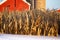 Standing corn stalks in snow in front of a red barn and silo