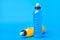 Standing and lying isotonic energy orange yellow and blue sport drink in plastic bottles on blue background