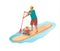 Standing man with boy is paddling with paddle board on the water