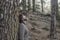 Standing man enjoying happiness and joyful feeling the outdoors nature park against a pine tree trunk. People and forest woods