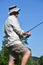 Standing Older Retiree Male Fisherman With Rod And Reel Fishing