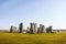 Standing rocks of ancient Stonehenge with defining shadows under clear blue sky on bright summer morning standing alone on