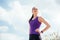 Standing sporty young beautiful woman before or after workout and running. Focused on exercises on sky background.