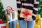 Standing woman hiding golden gift box behind her back from girl friend in christmas party