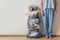 Standing woman legs near metal laundry basket full of dirty clothes and linen.