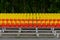 Stands of a small stadium with rows of yellow and red seats