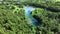 Standup paddleboarding on a winding forest river. Vacationers float downstream