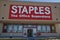 Staples retail store entrance and windows signs people inside