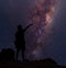 Star-catcher. A person is standing next to the Milky Way galaxy