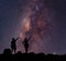 Star-catcher. A person is standing next to the Milky Way galaxy